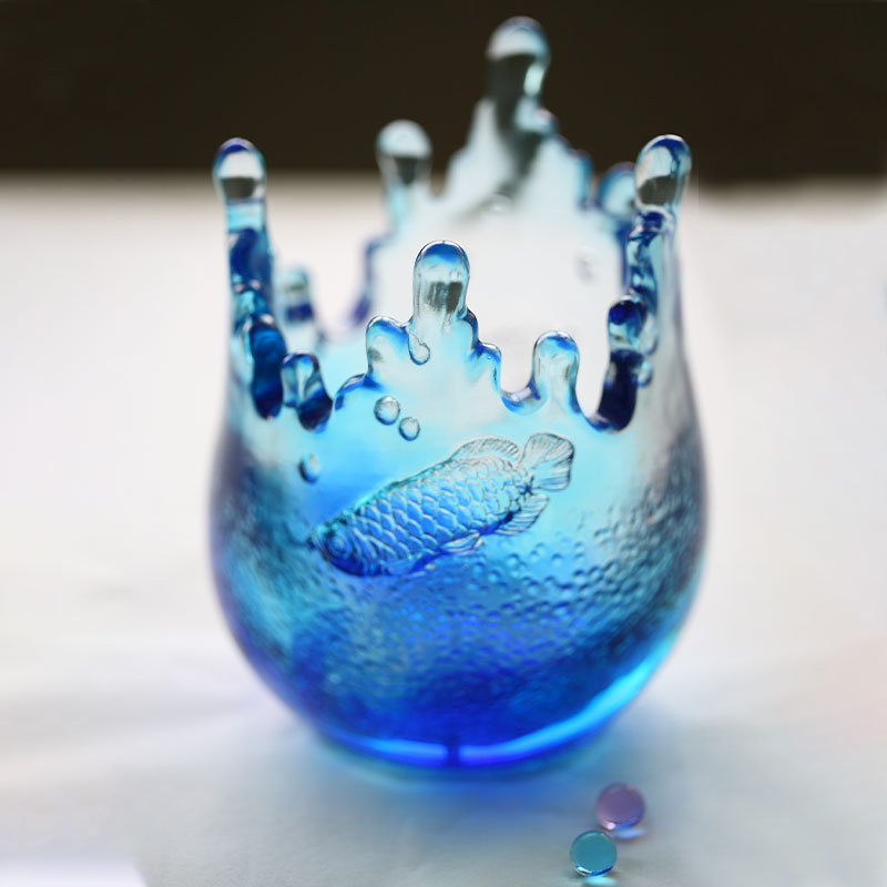 Adornos de cristalería azul grabados con motivos de peces.