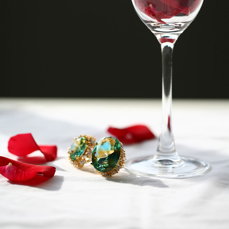 Pendientes de cristal verde con almohadillas doradas.