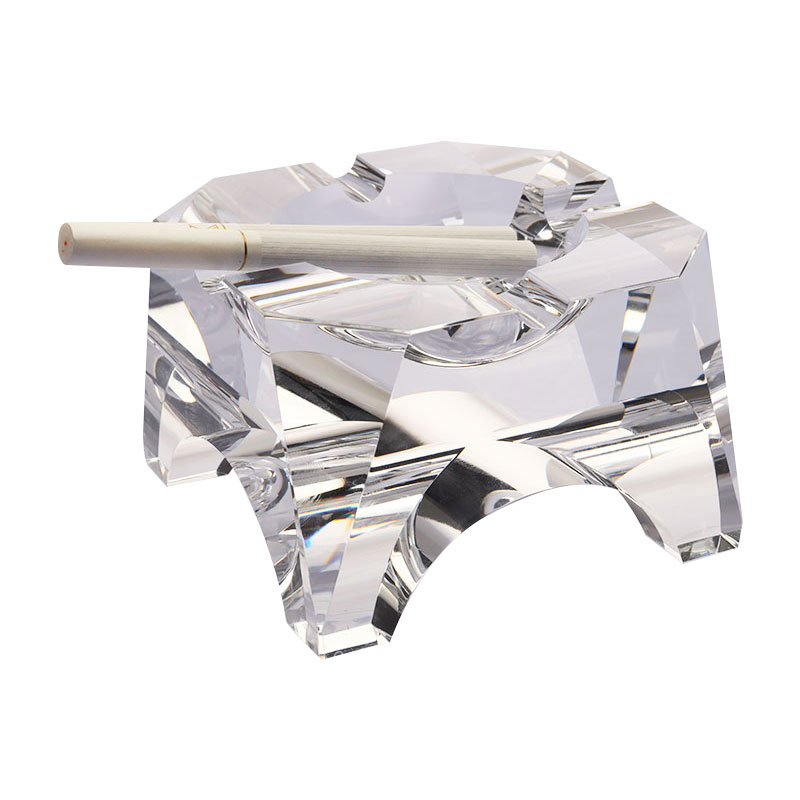 Cenicero de cristal transparente con diseño geométrico simple.