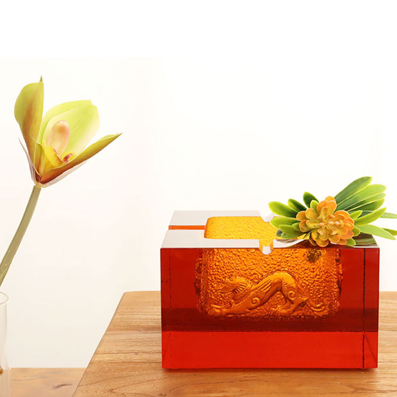 Cenicero de cristal rojo con exquisitos estampados de animales en relieve.