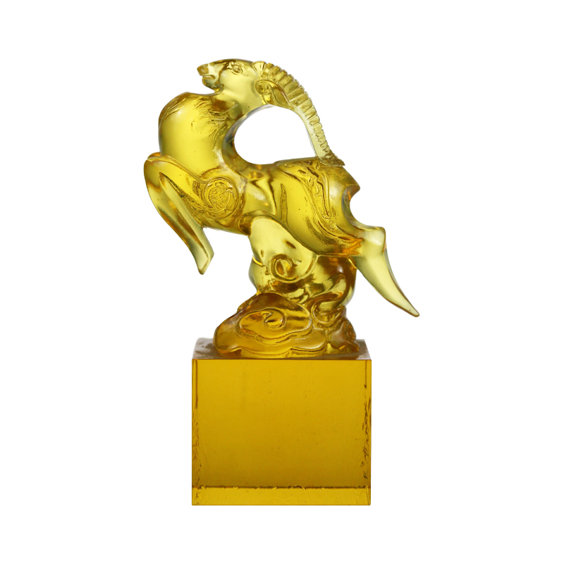 Sello de cristal transparente dorado con forma de oveja.