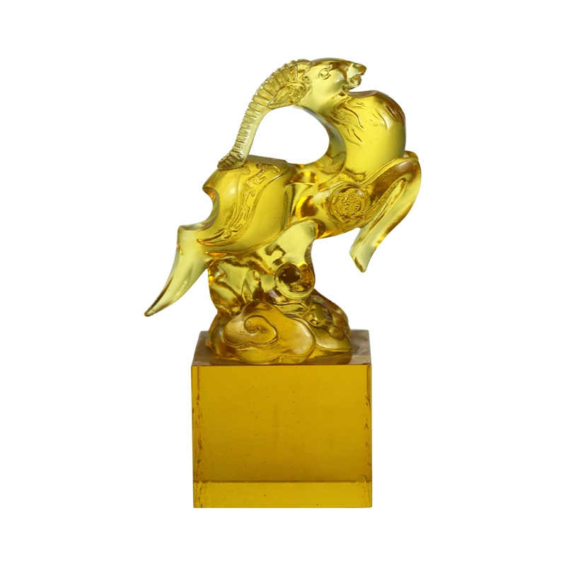 Sello de cristal transparente dorado con forma de oveja.